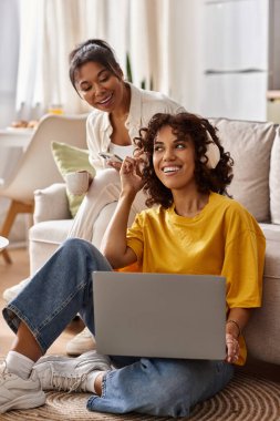 Çift, güneş ışığıyla dolu rahat, şık dairelerinde dizüstü bilgisayarlarıyla gülerken....