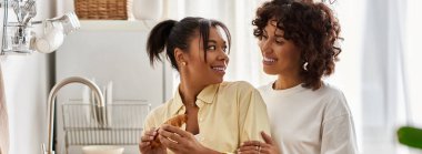 Two women enjoy a joyful breakfast in their stylish apartment, celebrating love and connection, banner clipart