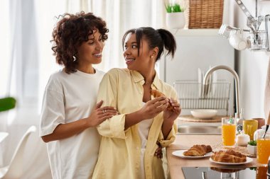 Two young women enjoy a cozy breakfast together, sharing joy and love. clipart