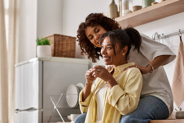 A young lesbian couple enjoys their time together, sharing laughter and warmth in a modern home.