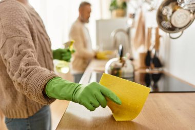 A mature couple works side by side, cleaning and organizing their kitchen with joy and teamwork. clipart