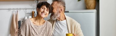 Olgun bir çift, mutfakta sıcaklığını ve kahkahasını paylaşarak birlikte vakit geçirmekten zevk alır..