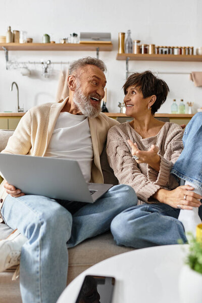 A cheerful couple engages in lively conversation while sitting together on a comfortable couch.