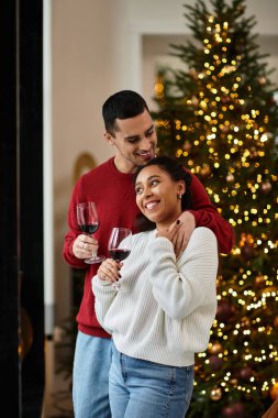 A couple enjoys a cozy moment together, celebrating the warmth of the holidays in their home. clipart