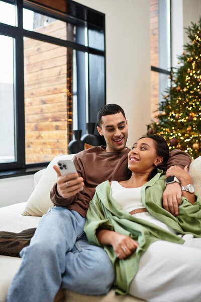 A couple shares quality time in their cozy, decorated apartment for Christmas.