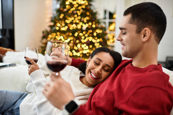Couple shares laughter and joy over glasses of wine in a beautifully decorated space.