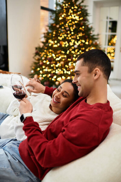 This couple enjoys each other's company, surrounded by festive decorations and a Christmas tree.