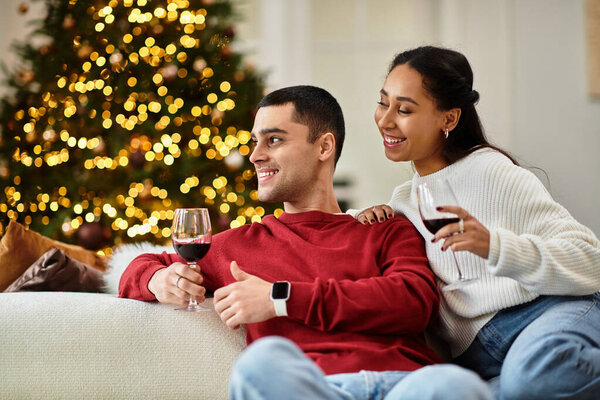 A couple enjoys a warm moment together in a brightly decorated apartment for Christmas.