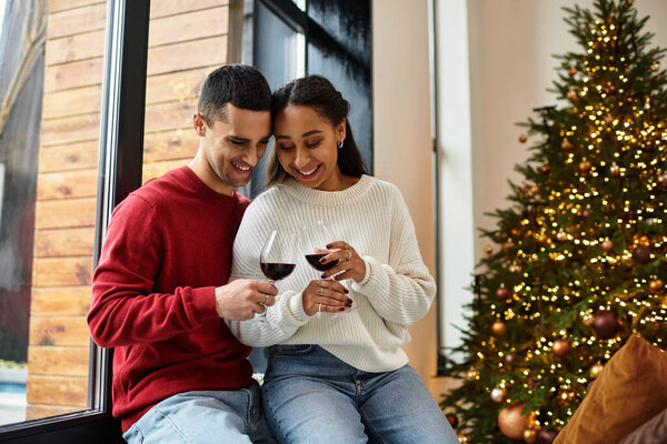 Charming couple relaxes with drinks, surrounded by festive decorations and holiday cheer.