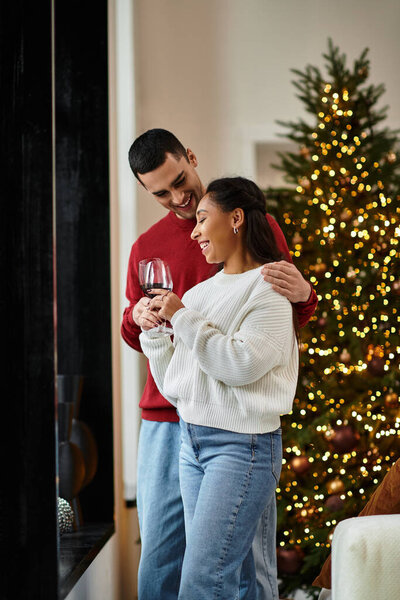 A couple shares laughter and love while celebrating Christmas in their modern living room.