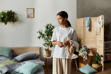 In a stylish apartment, a young woman organizes her space while handling cleaning tasks. clipart