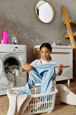 Young woman sorts laundry in a contemporary apartment while enjoying her daily chores. clipart