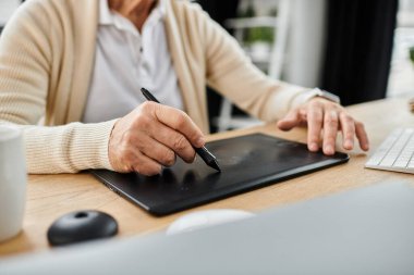 Yakışıklı son sınıf öğrencisi, parlak, şık bir ofis ortamında tablet kullanarak dijital sanat yaratıyor..