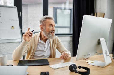 Olgun bir adam parlak bir ofis ortamında masa başında otururken fikirlerini tutkuyla paylaşır..