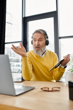 Kulaklıklı son sınıf öğrencisi, internetteki bir toplantıda fikirlerini tutkuyla tartışıyor.