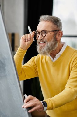 Yakışıklı son sınıf öğrencisi, çağdaş bir çalışma alanında çizim yaparken yaratıcılığını ifade ediyor..