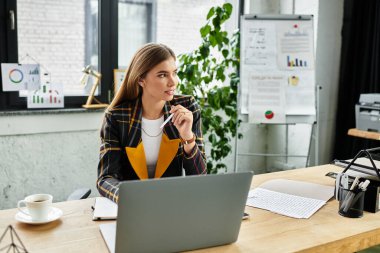 Modern bir ofis çalışma alanındaki görevlerine odaklanan şık bir iş kadını..