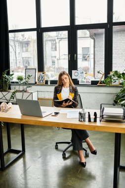 Şık, kareli ceketli genç bir kadın, modern ofis ortamında çalışmalarını sürdürüyor..