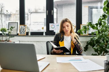 Modern bir ofis ortamında çalışırken genç bir kadın notları inceliyor..