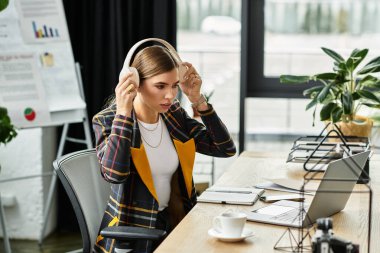 Kareli ceketli çekici bir iş kadını modern ofis masasında özenle çalışıyor..