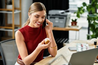 Çekici genç bir kadın akıllı telefonuyla güzellik ürünlerini tanıtarak neşe içinde etkileşime geçiyor.