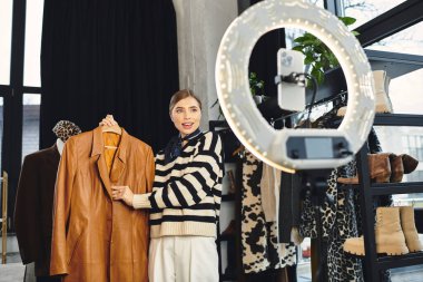 Çekici kadın şık kıyafetler sergiliyor ve takipçiler için moda fikirlerini kaydediyor..