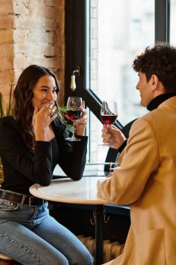 Güzel bir çift, sevgililer gününde şarapla kadeh kaldırarak romantik bir anı paylaşır..