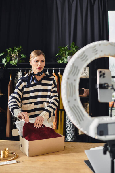 Молодая женщина умело курирует модный вид, взаимодействуя со своей аудиторией смартфона.