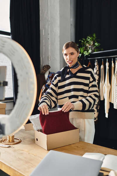 An attractive woman curates fashionable looks while recording her styling process for followers.