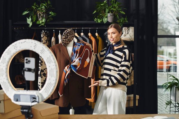 В яркой студии стильная женщина демонстрирует модный наряд, записывая свои советы по моде..