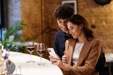 Sevgi dolu bir çift restoranda birlikte özel bir an geçirir, gülümseme ve içkileri paylaşırlar..