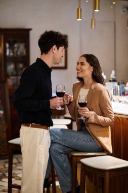 Genç çift, şarap, gülümseme ve samimi bir sohbetle romantik bir kutlamayı sever..