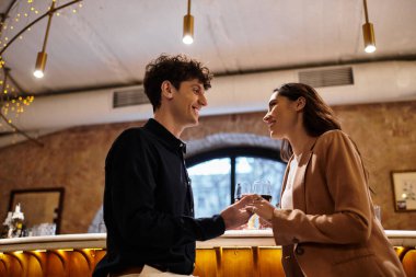 Genç çift, bir restoranda aşklarını kucaklarken, içkileriyle romantik bir anı paylaşıyor..