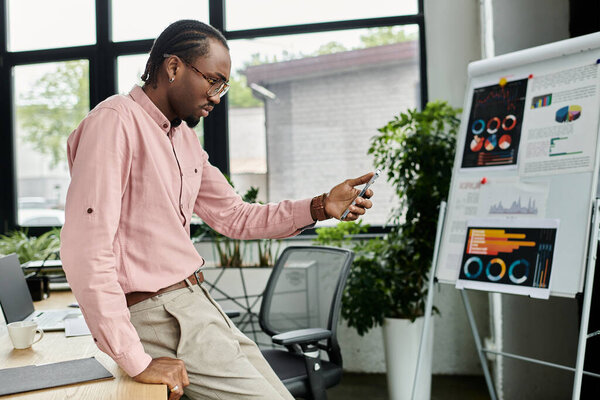 Сосредоточенный молодой человек использует технологии при анализе данных в яркой офисной среде