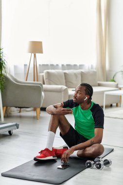 Odaklanmış genç adam evde uzak bir iş hayatı sürerken fitness yapıyor..
