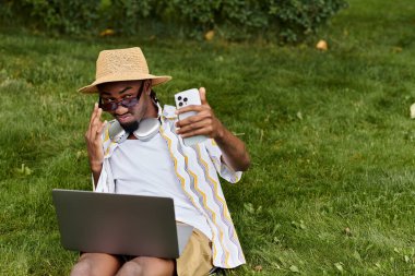 Genç adam akıllı telefonunu kullanırken canlı bir parkta uzaktan kumandayla çalışmaktan hoşlanıyor..