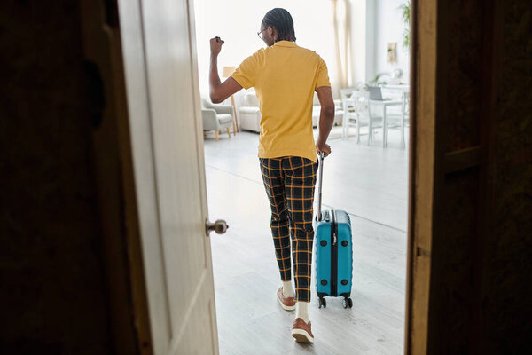 A young african american man is leaving his space, ready for a journey as a digital nomad.