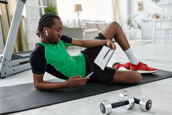 A determined young man engages in remote work while exercising on a mat in a modern home space.