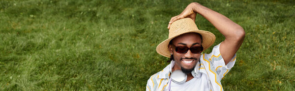 A young African American man relaxes outdoors, embracing the digital nomad lifestyle with joy.