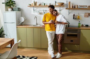 İki adam, şık evlerinde içki içerken sıcak bir kucaklaşmayı paylaşıyor..