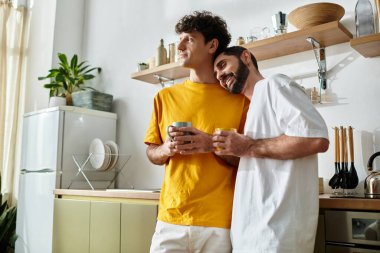 İki adam sıcacık mutfaklarında güzel bir anı paylaşıyor, birbirlerine eşlik ediyorlar..