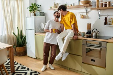 İki erkek, şık dairelerinde, birbirlerine eşlik etmekten zevk alarak, sevgi dolu bir anı paylaşıyorlar..