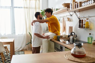 İki neşeli adam samimi evlerinde kucaklaşıp, aşklarını ve birlikteliklerini sevgiyle anarlar..