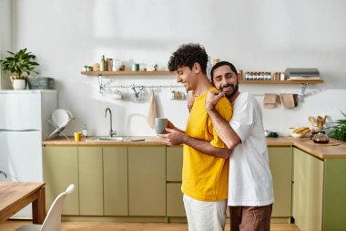 İki erkek evlerinde rahat evlerinde kahve içerken birlikte hoş bir anın tadını çıkarırlar..