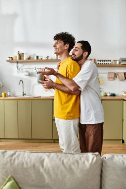 Eşcinsel bir çift şık dairelerinde rahatlarken şefkatli bir kucaklaşmanın tadını çıkarır..