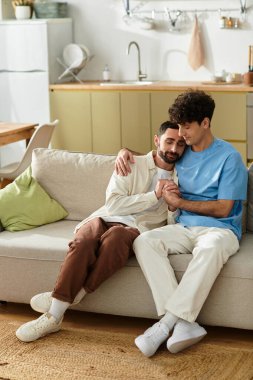 Two men in casual outfits share tender moments in their modern apartment. clipart