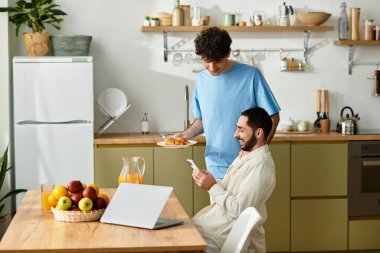 İki erkek, modern mutfaklarında yemek ve aşk üzerine sohbet ederek keyifli bir kahvaltı yaparlar..