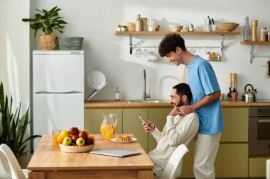 İki erkek, modern dairelerinde, aşk anlarını paylaşarak sıcak bir kahvaltıdan hoşlanırlar..