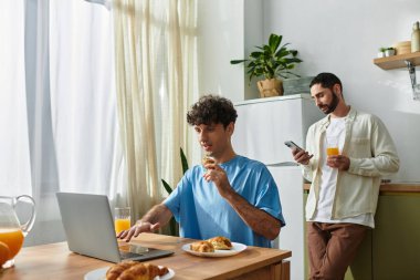 İki adam şık evlerinde kahvaltıdan zevk alıyor, yemeklerini ve kahkahalarını paylaşıyorlar..