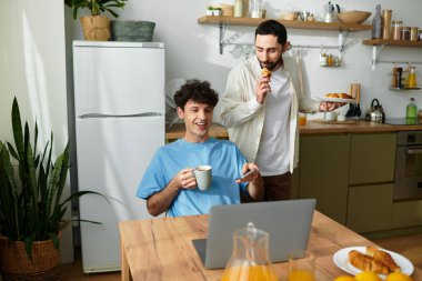İki erkek kahvaltıdan keyif alır, modern evlerinde gülümsemelerini ve lezzetli yemeklerini paylaşırlar..
